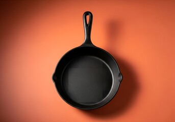Pristine Unbranded Premium Cast Iron Skillet with Matte Black Finish on Terracotta Orange Studio Background, Embodying Culinary Excellence and Durability.
