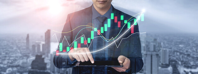 A professional businessman analyzes stock market trends using a digital tablet in front of an urban...