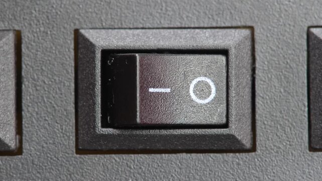 Finger pressing a two way on off switch turning off a generic electrical appliance electronic device power control button macro closeup detail saving energy simple abstract concept symbol one person