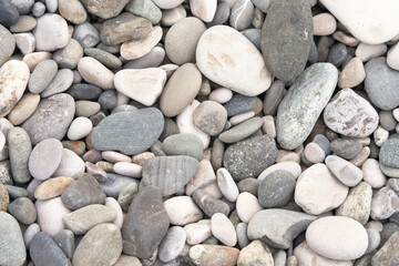 A pebble beach by the sea. Natural background in shades of gray.