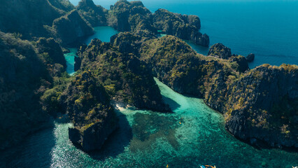 Scenic view of a blue lagoon over the calm sea with dark rocks in silhouette, creating a peaceful and natural coastal landscape.