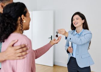 Young black couple receiving keys of new apartment from their real estate agent, standing in the new home