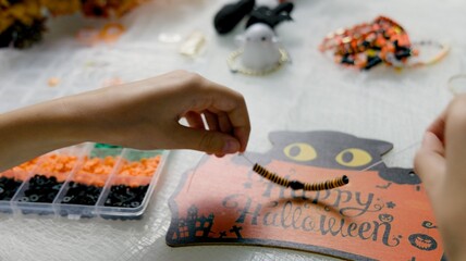 The child is preparing for Halloween, creating holiday decorations with their own hands.