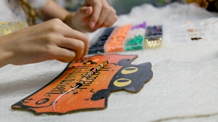 The child is preparing for Halloween, creating holiday decorations with their own hands.