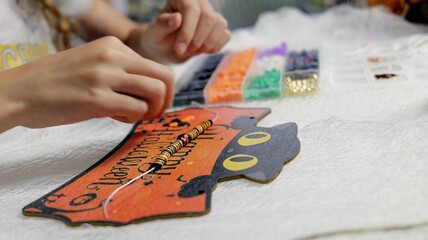 The child is preparing for Halloween, creating holiday decorations with their own hands.