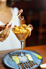 Ceviche served in a glass decorated with squid, octopus, lemon, and shrimp. Seafood platter.