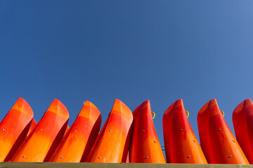 Minimalist Composition of Red Kayaks Against Clear Blue Sky