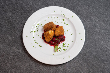 Crispy Fried Camembert Cheese with Sweet Cranberry Sauce on White Plate. Gourmet Appetizer Dish