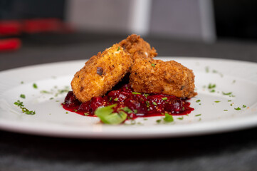 Crispy Fried Camembert Cheese with Sweet Cranberry Sauce on White Plate. Gourmet Appetizer Dish