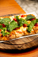 margherita pinsa pizza with basil and cherry tomatoes portrait