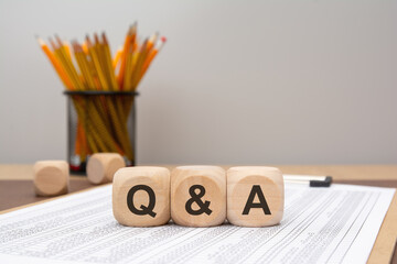 Wooden cubes spelling Q and A on financial document