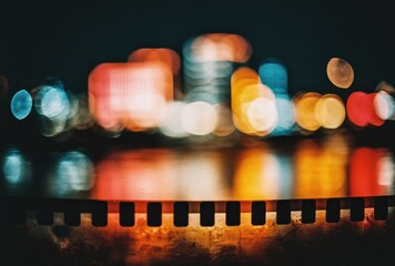 Abstracted night cityscape with blurred lights and filmstrip foreground