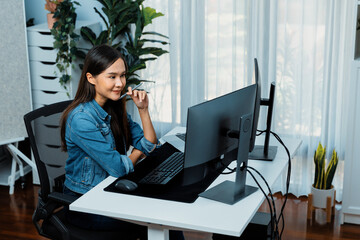 Obraz premium Young Asian IT developer looking online information on pc for beautiful pose with coding program data of website application, wearing jeans shirt. surround by safety analysis two screens. Stratagem.