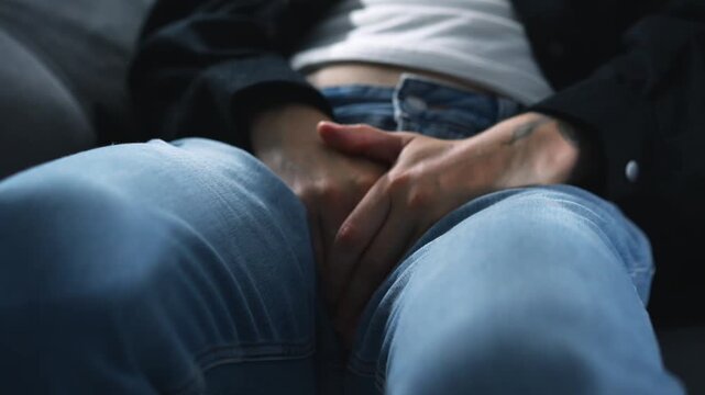 A man can't hold it in for long and needs to go to the bathroom.
A man on a couch clutches his penis and experiences severe pain in his groin area.
Sexually transmitted diseases