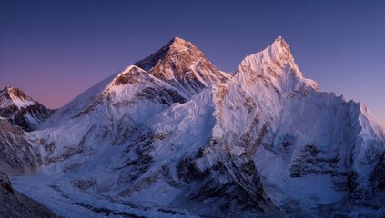 Fototapeta premium Majestic snow-capped mountains, lit by early morning sun, against a gradient purple sky