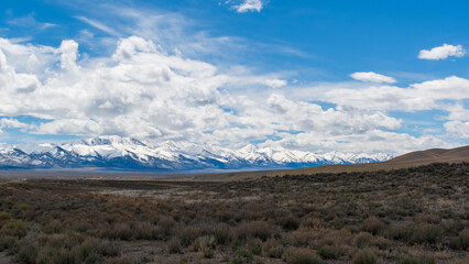Nevada Desert Scrubland with Snow-Capped Mountains and Mostly Cloudy Spring Sky