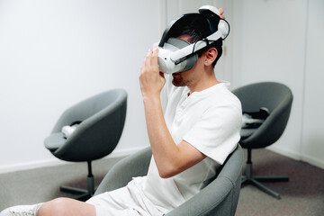 One guy takes off his virtual reality glasses indoors.