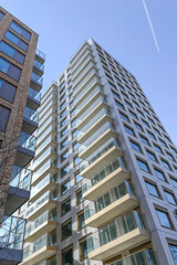 Low-angle view of building facade against a light teal sky, showcasing modern architecture and design, urban, London, United Kingdom, 8 March 2025
