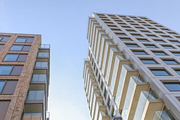 144 Low-angle view of building facade against a light teal sky, showcasing modern architecture and design, urban, London, United Kingdom, 8 March 2025