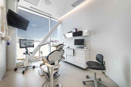 Modern dental office interior with reception desk, patient chairs, treatment rooms and professional equipment. Bright clean environment designed for healthcare and dentistry services, including x-ray 
