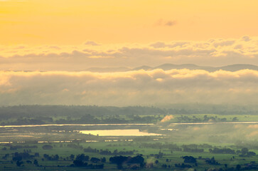Beautiful scenery of green rice fields, huts, trees and mountains in the countryside of Phayao Province, Northern Thailand.