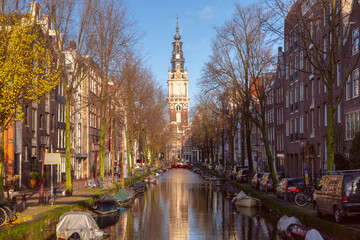 View of Zuiderkerk church tower and boats along canal in Amsterdam Netherlands
