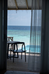 Ocean view from resort villa with chairs and pool