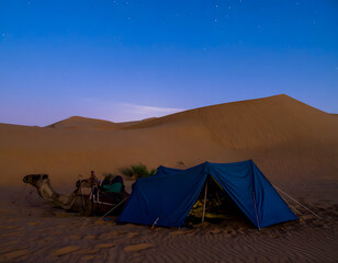 Blue tent pitched in a desert environment under the night sky