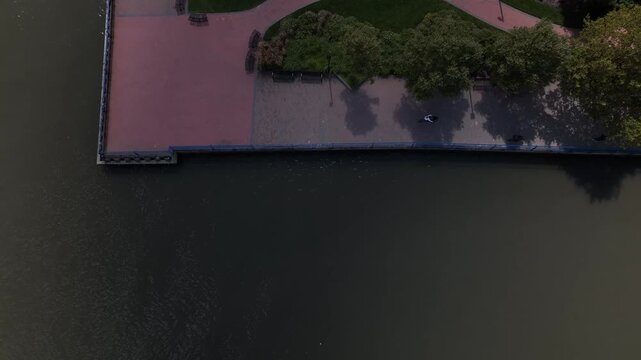Riding a bike in a public park past the Hudson River in New Jersey across the water from New York City 