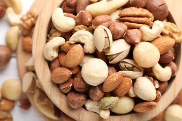 Mix of different nuts in bowl on table, top view