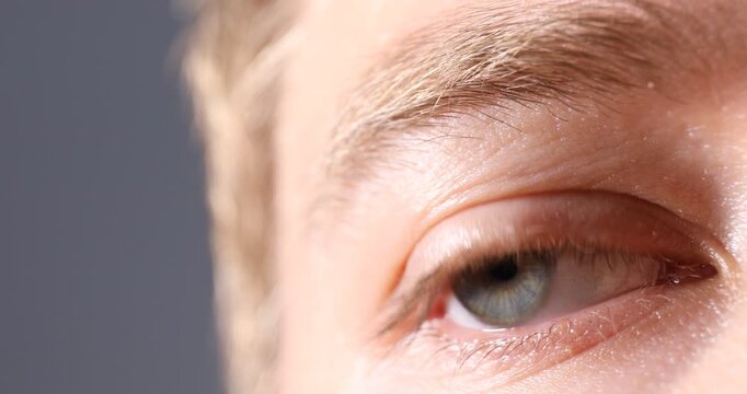 Man with beautiful eyes on grey background, closeup