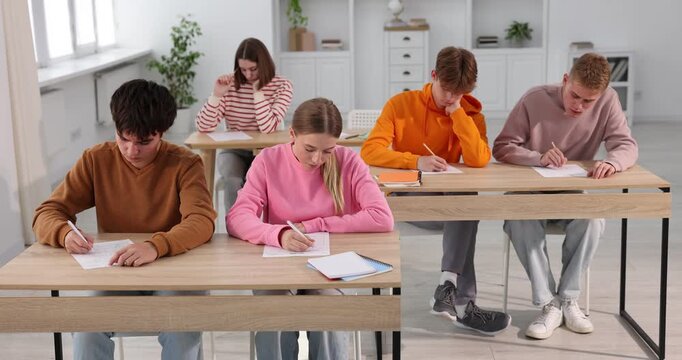 Students taking exam at wooden table indoors