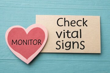 Paper Heart Icon Labeled Monitor beside Wooden Sign for Vital Signs