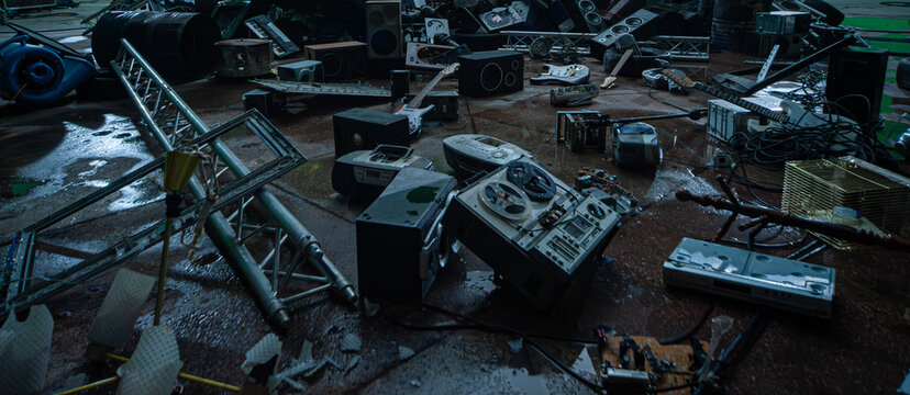 Dark blurred abstract musical techno background with vintage broken discarded musical instruments amplifiers tape recorders speakers guitars stage equipment and accessories