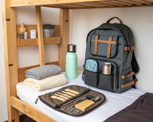 Minimalist zero-waste travel kit laid out on a hostel bed. Sustainable backpacking, eco-friendly travel, responsible tourism, and conscious packing concept.