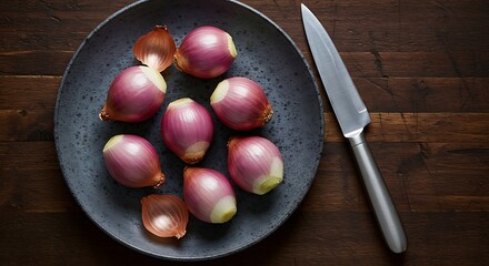 Fresh Red Shallots on Gray Plate with Stainless Steel Knife on Dark Wood