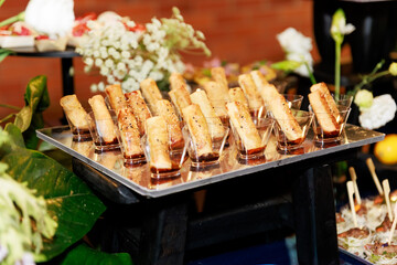 Spring Roll Appetizers with Sesame Seeds Served in Individual Glasses with Dipping Sauce on Tray
