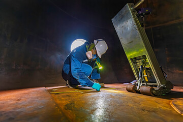 Male worker inspection floor scan tank oil of rust wall, loss of thickness bottom plate in the manhole tank to work inside