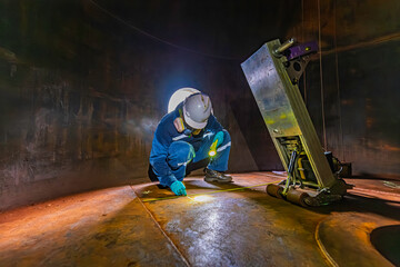 Male worker inspection floor scan tank oil of rust wall, loss of thickness bottom plate in the...