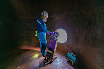 Male worker inspection floor scan tank oil of rust wall, loss of thickness bottom plate in the manhole tank to work inside