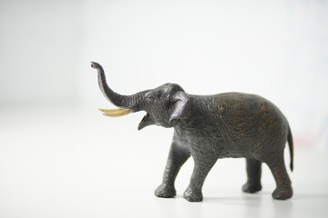 Miniature elephant figurine with tusks raised in a clean studio setting