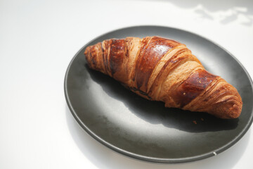 Freshly baked croissant on a round plate