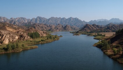 Winding River Through Rocky Valley Under Clear Blue Sky in Western China