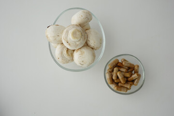 Mushrooms and dietary supplements on a clean surface