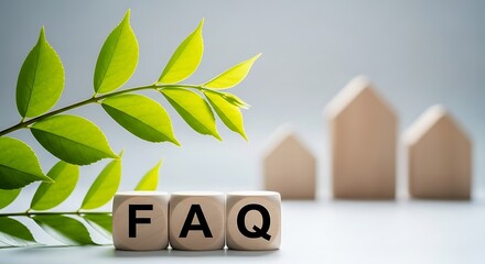 Frequently asked questions faq spelled out on wooden blocks with a green plant and blurred house models in the background