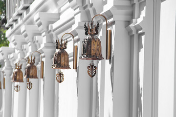 Bell hanging on white wall in Thailand temple background