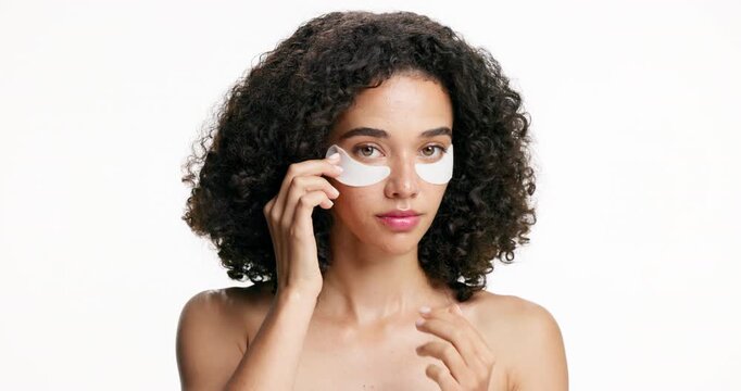 Beauty, face and woman with eye patches in studio for dark circles, hydration treatment or self care. Mockup space, girl or product application for anti aging, skin glow or depuff on white background