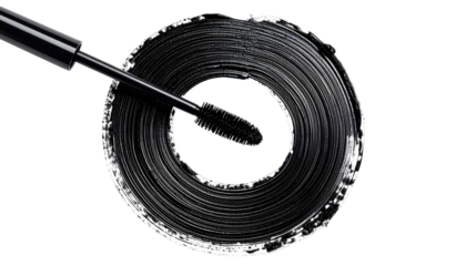Black mascara smudge in a circular pattern.  A mascara wand positioned above a dark smudged circle of black cosmetic product
