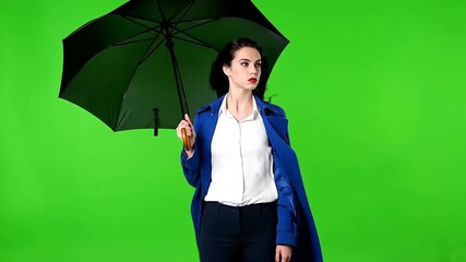 Stylish Woman in Blue Trench Coat Opening Umbrella Against Wind on Green Screen Background