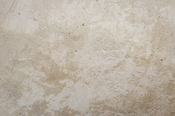 Fototapeta premium Stucco or Weathered Wall Background: Light Pale Beige Texture with Irregular Spots and Gray Tones.